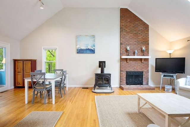 94 Pine View Dr, Brewster, MA 02631 - living area with a wood stove, high vaulted ceiling, and light wood-style floors