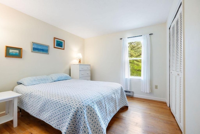 94 Pine View Dr, Brewster, MA 02631 - bedroom featuring a baseboard radiator, wood finished floors, and a closet