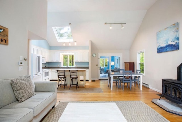 94 Pine View Dr, Brewster, MA 02631 - living room with rail lighting, a wood stove, high vaulted ceiling, a skylight, and plenty of natural light