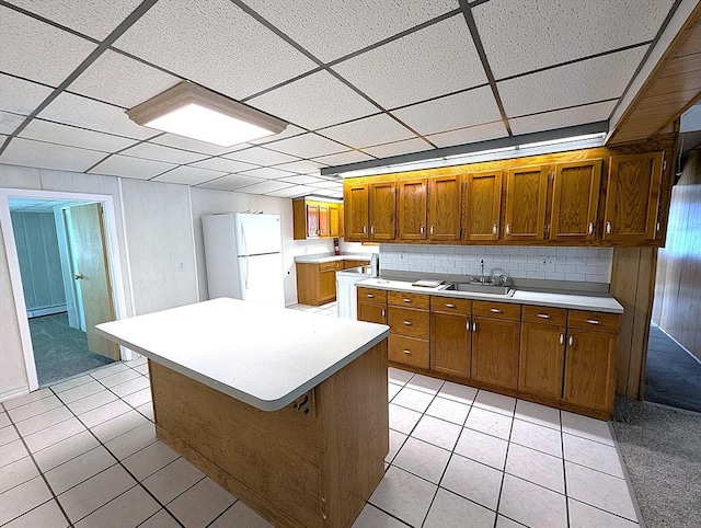 22-24 Newton Ave, Tewksbury, MA 01876 - kitchen featuring freestanding refrigerator, brown cabinetry, a paneled ceiling, light countertops, and light tile patterned floors