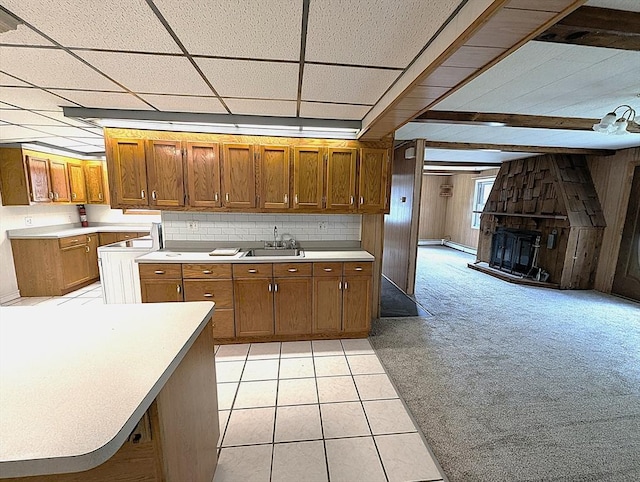 22-24 Newton Ave, Tewksbury, MA 01876 - kitchen with brown cabinetry, a sink, light countertops, a fireplace, and wooden walls