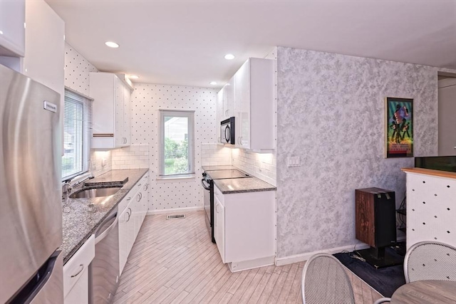 1 Astra Unit 1, Wayland, MA 01778 - kitchen with appliances with stainless steel finishes, white cabinets, a sink, stone countertops, and recessed lighting