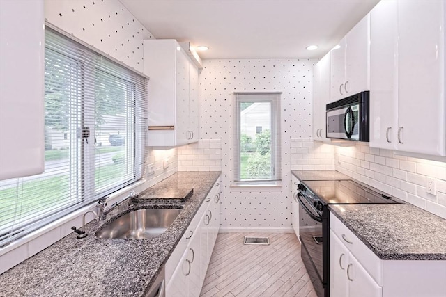 1 Astra Unit 1, Wayland, MA 01778 - kitchen featuring black appliances, a sink, white cabinets, backsplash, and recessed lighting