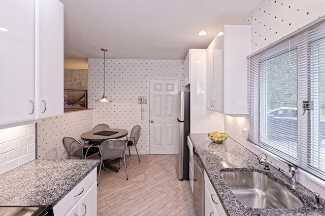 1 Astra Unit 1, Wayland, MA 01778 - kitchen with a sink, stainless steel appliances, white cabinetry, and dark stone countertops