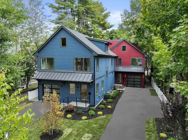 110 Harvard St, Newton, MA 02460 - view of front facade with a standing seam roof, an attached garage, covered porch, and driveway
