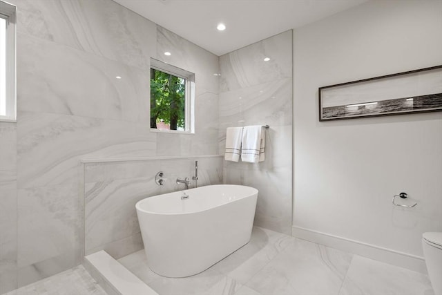 110 Harvard St, Newton, MA 02460 - full bath with a freestanding bath, marble finish floor, tile walls, and toilet