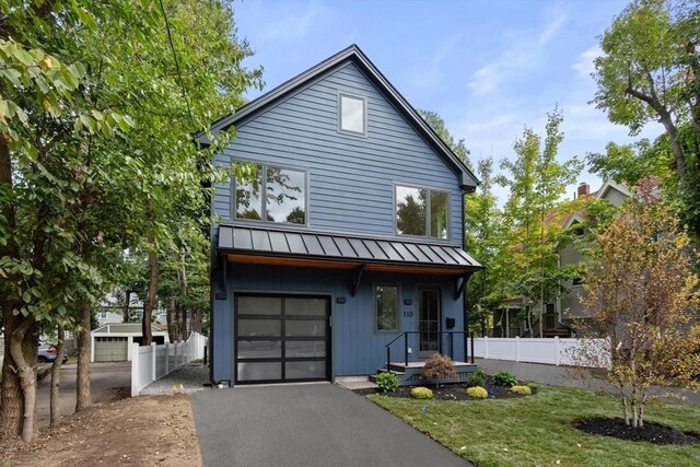 110 Harvard St, Newton, MA 02460 - view of home's exterior featuring a standing seam roof, a garage, metal roof, fence, and driveway