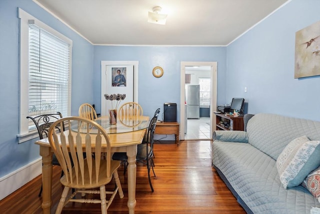 dining area with dark hardwood / wood-style floors and ornamental molding