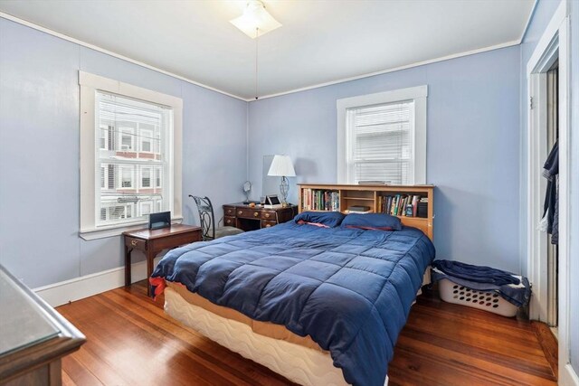 bedroom featuring crown molding and dark wood-type flooring