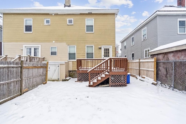 snow covered rear of property featuring a wooden deck