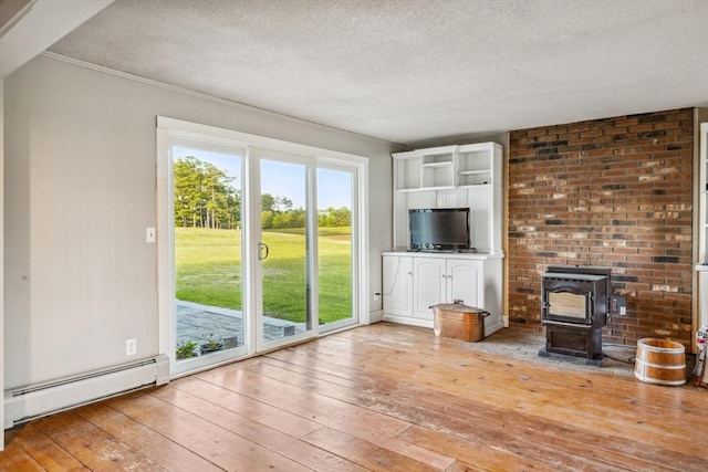 79 Wapping Rd, Kingston, MA 02364 - unfurnished living room with baseboard heating, a wood stove, hardwood / wood-style floors, and a textured ceiling