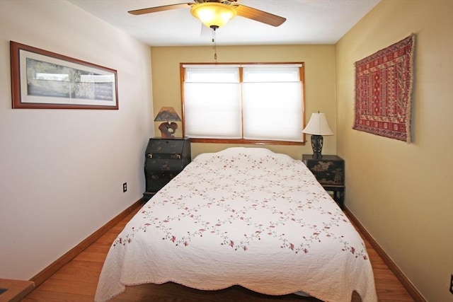 bedroom with a ceiling fan, baseboards, and wood finished floors