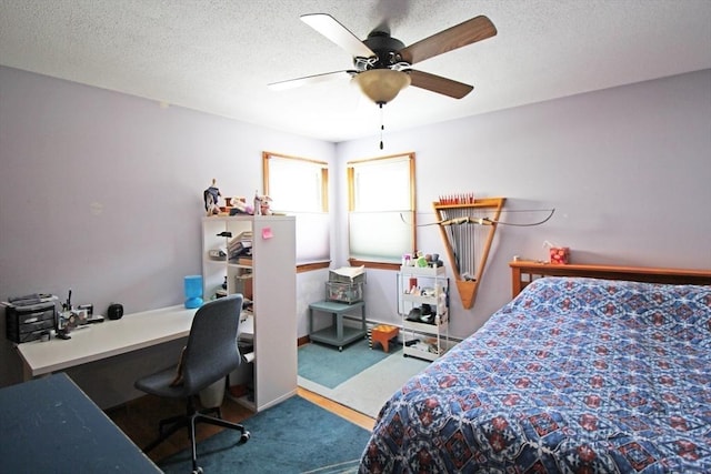 bedroom featuring a ceiling fan, carpet flooring, and a textured ceiling