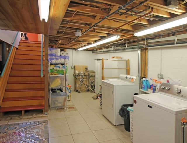 clothes washing area with washer and dryer, laundry area, and light tile patterned flooring