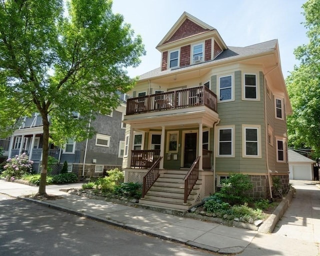 view of front of home with a balcony, covered porch, stairway, and a garage