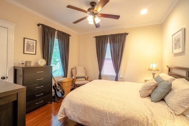 bedroom featuring dark wood-style floors, ornamental molding, and ceiling fan
