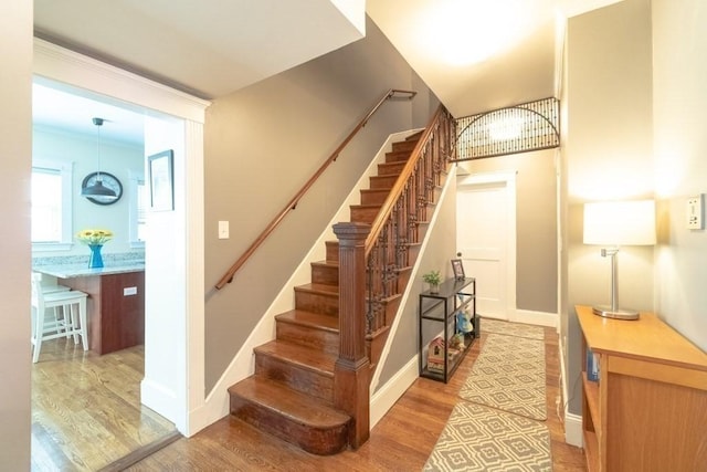 staircase with wood finished floors and baseboards