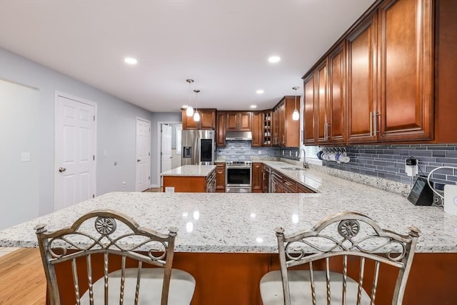 66 Eagle Dr, Dudley, MA 01571 - kitchen with appliances with stainless steel finishes, under cabinet range hood, a sink, light stone counters, and recessed lighting
