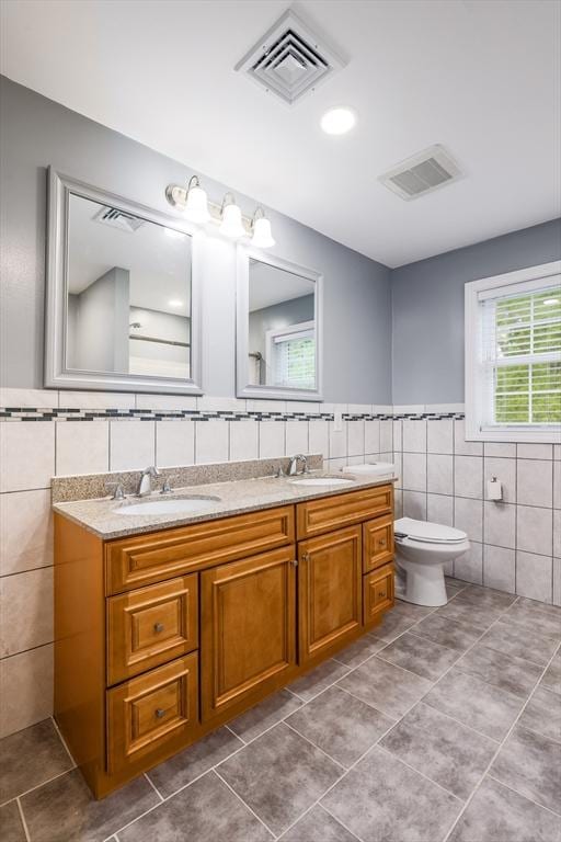 66 Eagle Dr, Dudley, MA 01571 - full bath featuring tile walls, double vanity, tile patterned floors, toilet, and a wainscoted wall