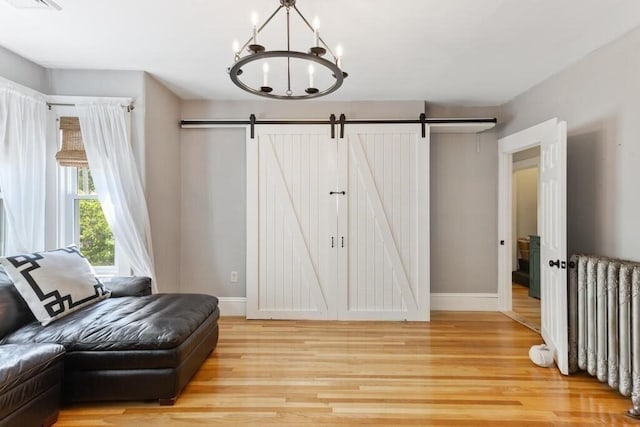 29-31 Bancroft Ave, Reading, MA 01867 - living area featuring radiator, light wood-style floors, a chandelier, and a barn door