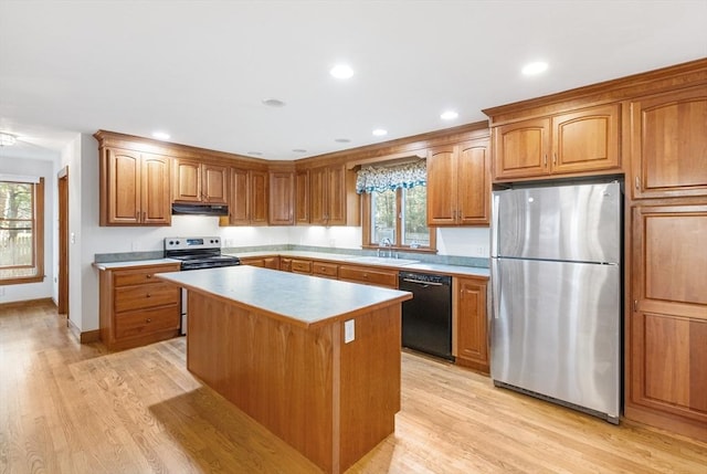 kitchen with sink, a kitchen island, stainless steel appliances, and light hardwood / wood-style flooring