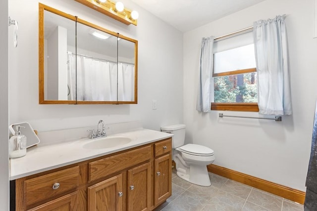 bathroom with tile patterned flooring, vanity, and toilet