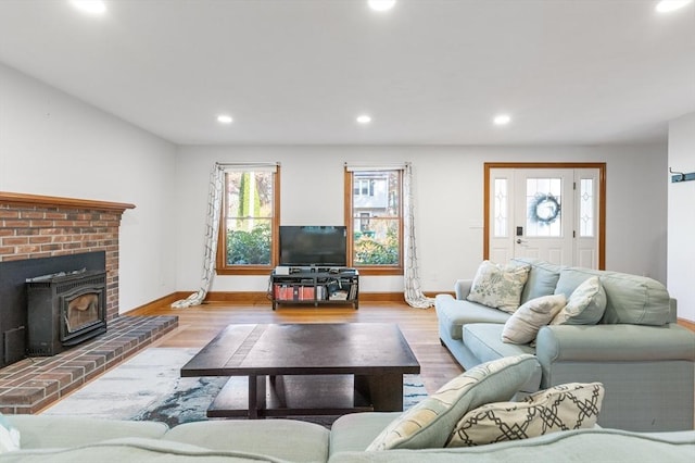 living room with light wood-type flooring and a wood stove