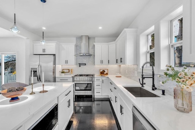 kitchen with wall chimney exhaust hood, stainless steel appliances, a sink, plenty of natural light, and recessed lighting