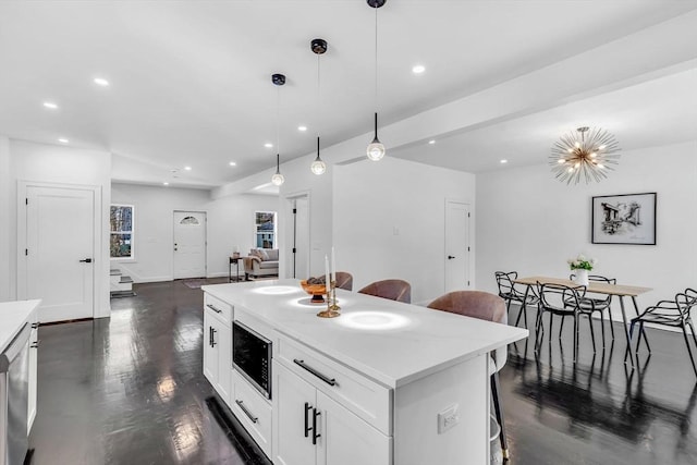 kitchen featuring built in microwave, open floor plan, a breakfast bar, recessed lighting, and dark wood-type flooring