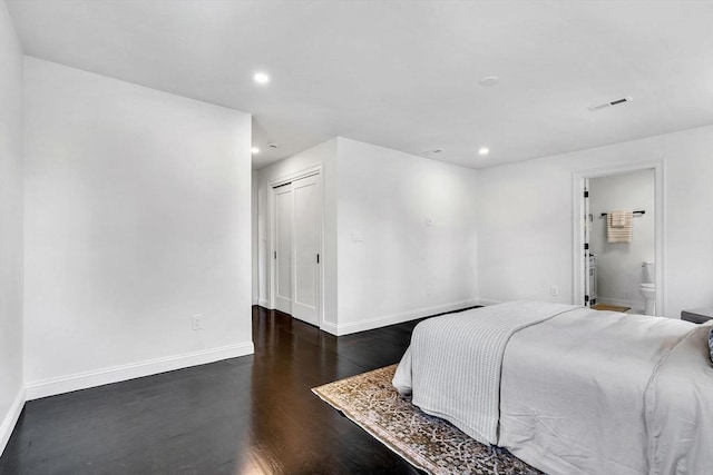 bedroom featuring wood finished floors, baseboards, recessed lighting, a closet, and ensuite bath