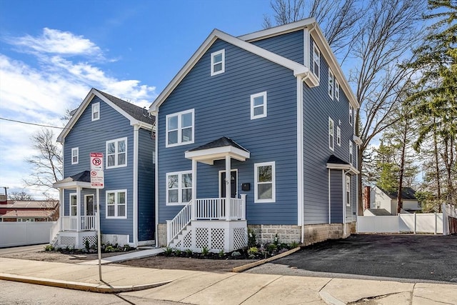view of front of property featuring fence and asphalt driveway