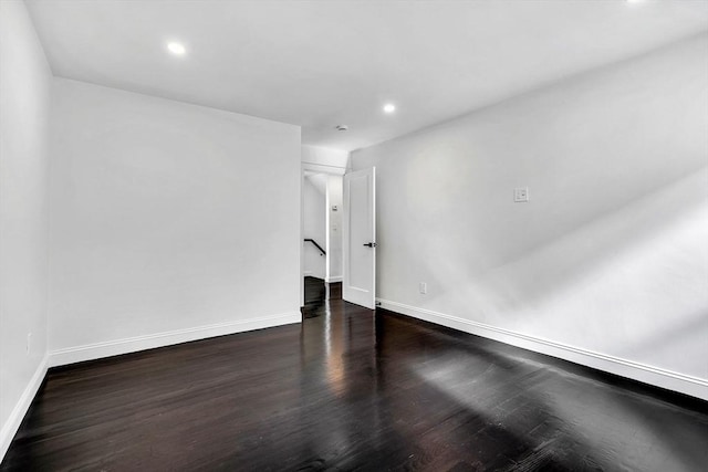 unfurnished room featuring baseboards, dark wood-style flooring, and recessed lighting