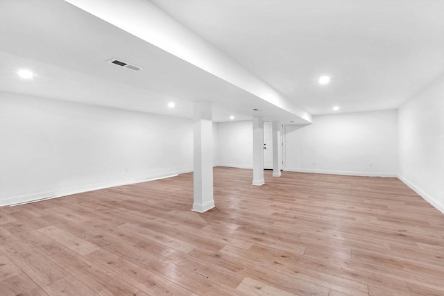 finished below grade area with light wood finished floors, baseboards, and recessed lighting