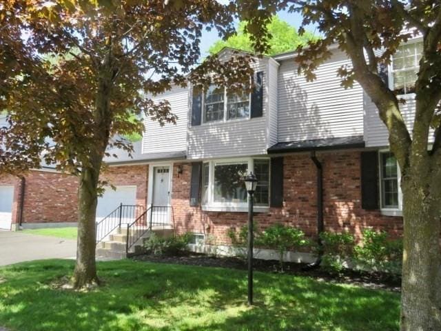 19 Hadley St Unit 14, South Hadley, MA 01075 - view of front of property featuring an attached garage, brick siding, a front yard, and driveway