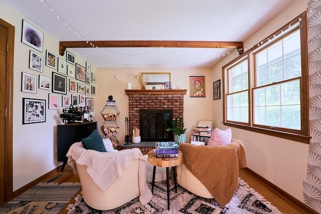 19 Hadley St Unit 14, South Hadley, MA 01075 - living area featuring beam ceiling, baseboards, wood finished floors, and a brick fireplace