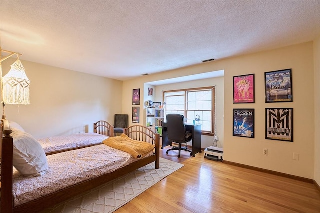 19 Hadley St Unit 14, South Hadley, MA 01075 - bedroom featuring light wood finished floors, a textured ceiling, an office area, and baseboards