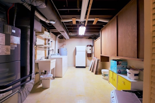 19 Hadley St Unit 14, South Hadley, MA 01075 - unfinished below grade area with washer and dryer, freestanding refrigerator, tile patterned floors, water heater, and a central vacuum unit