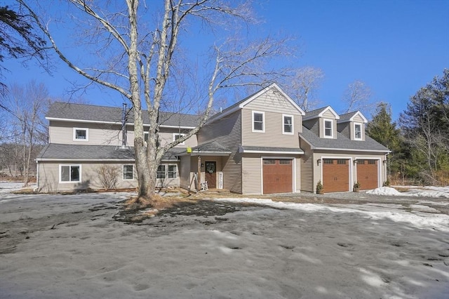 view of front facade with a garage and a shingled roof