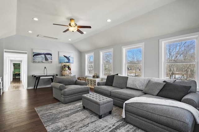 living area with lofted ceiling, a healthy amount of sunlight, dark wood-style flooring, and visible vents