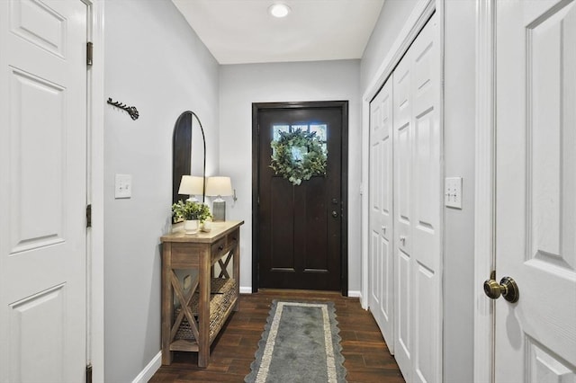 foyer entrance with dark wood finished floors and baseboards