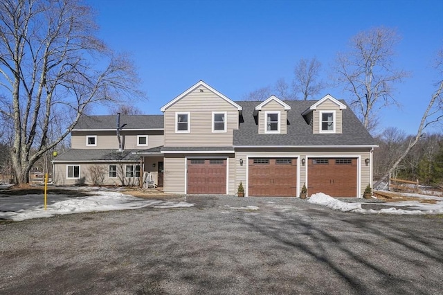 view of front of house featuring driveway, a garage, and roof with shingles