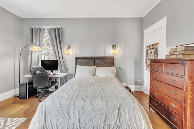 bedroom featuring light wood-type flooring and ornamental molding