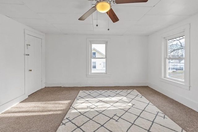 carpeted spare room featuring ceiling fan