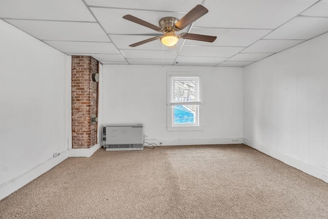 spare room with a paneled ceiling, ceiling fan, carpet floors, and heating unit