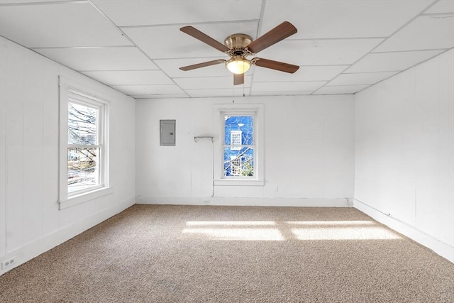 unfurnished room with carpet floors, electric panel, a drop ceiling, and ceiling fan