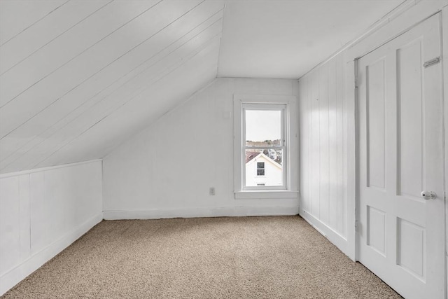 additional living space with carpet flooring and lofted ceiling