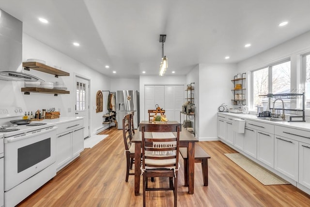 kitchen featuring white cabinetry, electric range, decorative light fixtures, and stainless steel refrigerator with ice dispenser