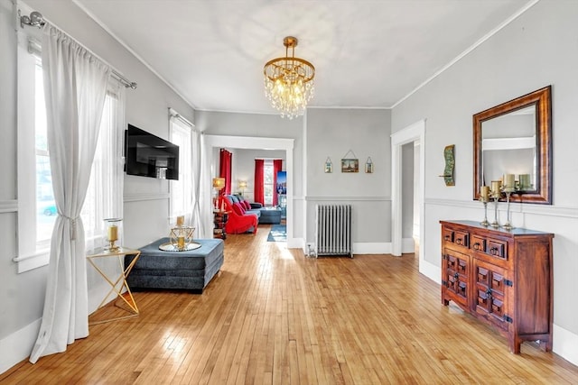 interior space featuring plenty of natural light, light hardwood / wood-style floors, radiator heating unit, and a chandelier