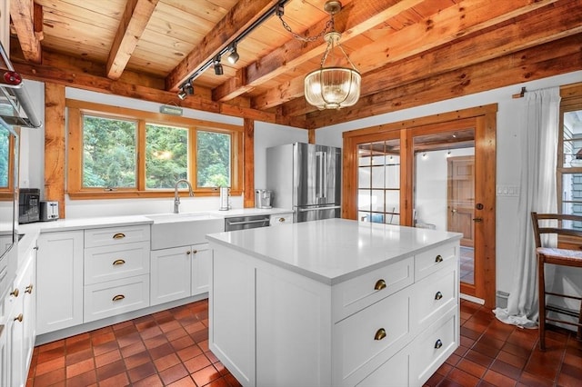 kitchen with wooden ceiling, stainless steel appliances, a sink, light countertops, and beam ceiling