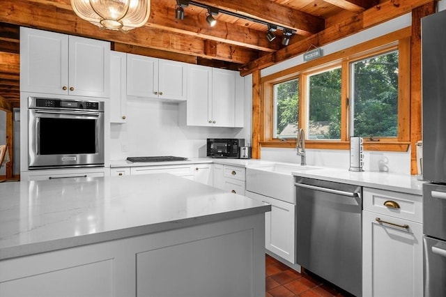 kitchen with appliances with stainless steel finishes, white cabinets, a sink, wooden ceiling, and beamed ceiling